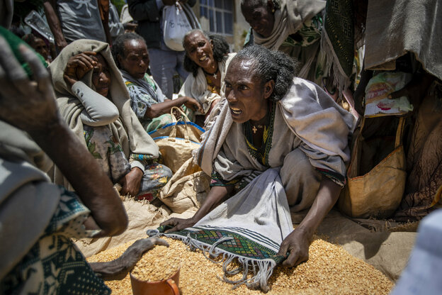 Eine Äthiopierin streitet mit anderen über die Zuteilung von gelben Spalterbsen