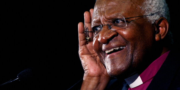 Desmond Tutu hört zu und lächelt