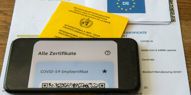 Ein Impfnachweis im Handy, ein Impfpass und ein EU-Impfzertifikat