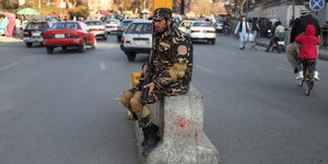 Ein bewaffneter Taliban sitzt an einem Checkpoint in Kabul