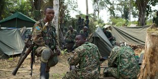 Soldaten sitzen zwischen Zelten