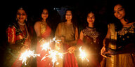 Fünf Frauen in indischen Kleidern mit Wunderkerzen