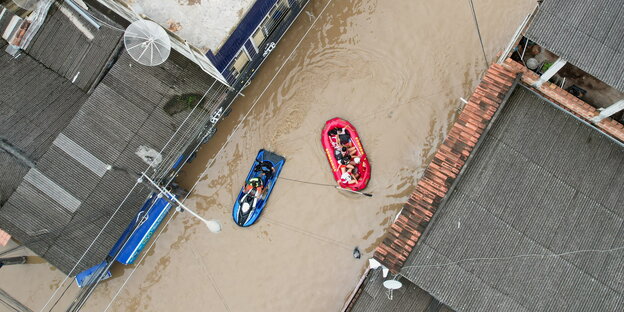 Rettungsboote in einer überschwemmten Straße.