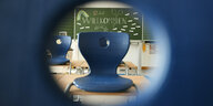 Blick in ein Klassenzimmer mit hochgestellten Stühlen.