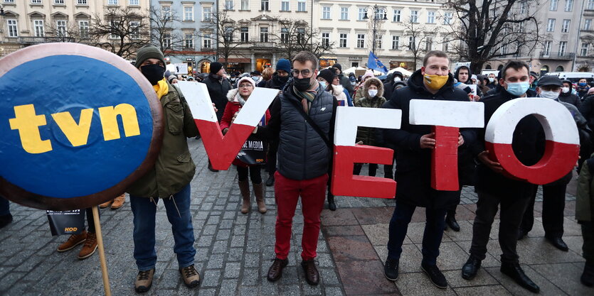 Menschen halten Buchsraben in die Höhe, die das Wort Veto ergeben