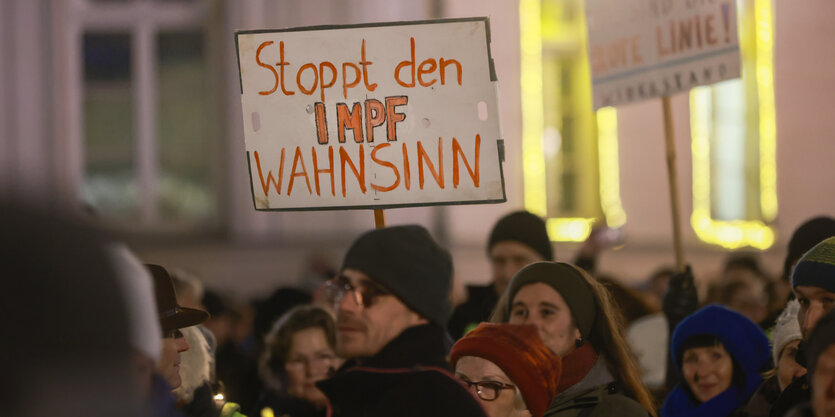 Demonstranten mit Schild "Stoppt den Impfwahnsinn"