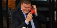 Hamburgs Finanzsenator Andreas Dressel nimmt eine rote FFP2-Maske ab und lacht