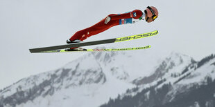 Skispringer Kraft, im Hintergrund Berge.