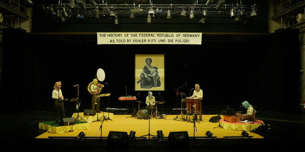 Musiker:innen der Performance „The History of the Federal Republic of Germany“ von Fehler Kuti und Die Polizei auf einer Bühne