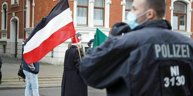 Ein Demonstrant hält eine Reichkriegsflagge während einer Neonazi Demo