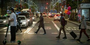 Menschen überqueren eine Hauptstraße in der Madrider Innenstadt