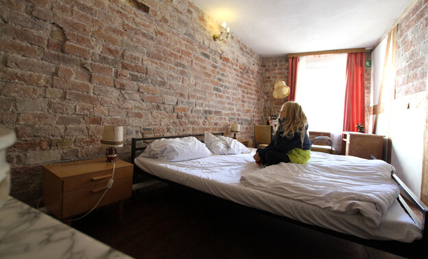 Ein Hotelzimmer, das mit nackten Wänden gerade mal so groß ist, dass das Bett an beide Wände stößt - man muss eben drüber klettern, wenn man zum Fenster will Ein Hotelzimmer, das mit nackten Wänden gerade mal so groß ist, dass das Bett an beide Wände stößt - man muss eben drüber klettern, wenn man zum Fenster will