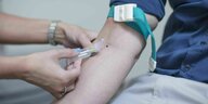 Eine Krankenschwester nimmt einem Patienten Blut ab