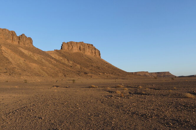 Eine Hügelkette in der Wüste vor blauem Himmel