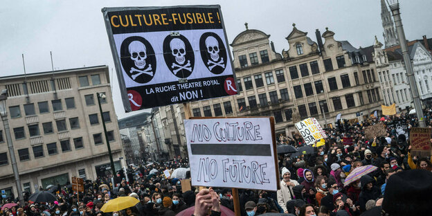 Demonstrantion mit Plakaten mit Totenköpfen