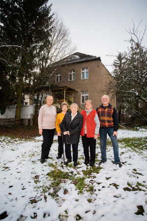 Fünf Menschen stehen in einem Garten Fünf Menschen stehen in einem Garten