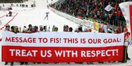 Wintersportler in Norwegen halten einen Protestplakat "Treat us with respect" in die Höhe