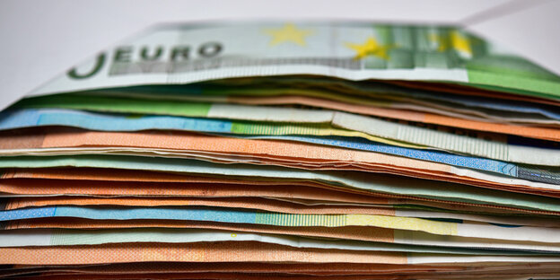 Viele Eurobanknoten liegen in einem Briefumschlag auf einem Tisch - ein illustrierendes Foto zur Kolumne um Geld und Geldverbrennung