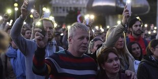 Demonstranten halten ihre leuchtenden Handys hoch bei einer Gedenkveranstaltung