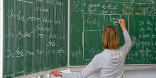 eine Lehrerin steht an einer Tafel