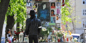 Ein Michael-Jackson-Darsteller steht vor dem Denkmal in München