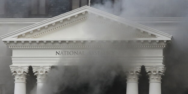 Aus einem Gebäude mit weißen Säulen dringt Rauch