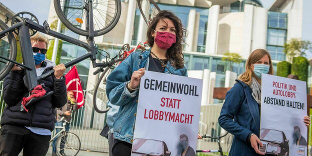 Gemeinwohl statt Lobbymacht und ein Auto, Frauen halten Plakate vor dem Kanzleramt