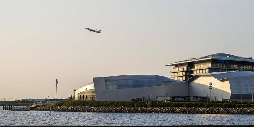 Ein Flugzeug startet vor einem Gebäude