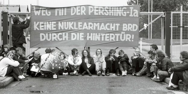 Sitzstreik gegen die Stationierung von Pershing Raketen in Geilenkirchen. Die Demonstranten halten ein Schild: Keine Nuklearmacht BRD durch die Hintertür
