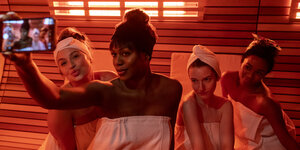 Szene aus der Serie: Vier Frauen machen ein Selfie in der Sauna Szene aus der Serie: Vier Frauen machen ein Selfie in der Sauna