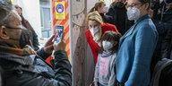 Das Foto zeigt Regierungschefin Franziska Giffey (SPD) mit Maske neben einem Kidn an einem Impfzentrum.