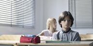 Zwei Schulkinder sitzen in einem Klassenzimmer.