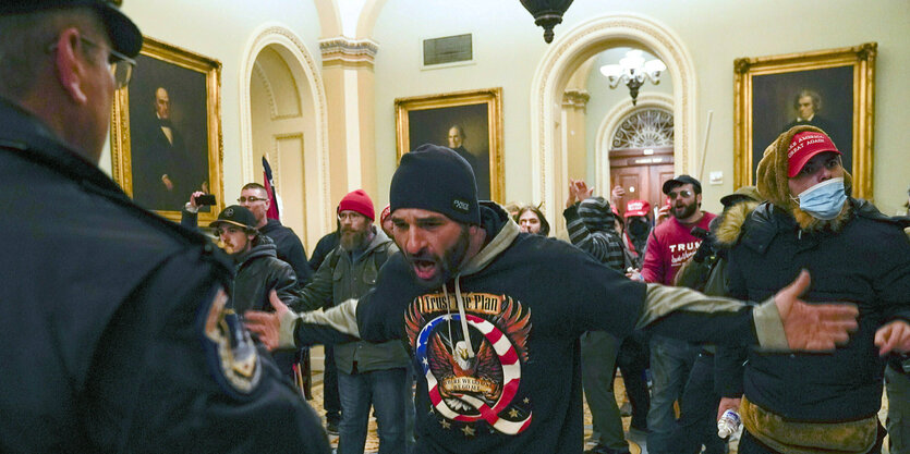 Trump-Anhänger stellen sich bedrohlich vor einen Capitol-Polizisten