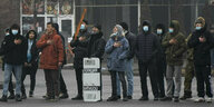 Demonstranten stehen in Almaty in einer Reihe und singen