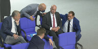 Rpdiger Lucassen umringt vor AFDlern im Bundestag, neben ihm kniet Tino Chrupalla