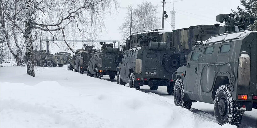 Grüne Militärfahrzeuge fahren durch den weißen Schnee