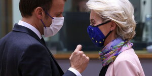 Macron und von der Leyen stehen sich mit Maske gegenüber