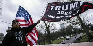 Ein junger Mann mit US- und Trump 2024 Flagge
