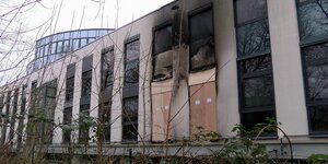 Das OHB-Gebäude in Bremen nach dem Brandanschlag; zwei der haushohen Fenster sind zerstört und teilweise durch Spanplatten ersetzt. Die Rußspuren reichen bis zum Dach