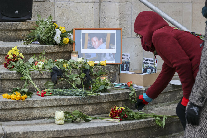 Jemand legt Blumen zum Gedenken an Oury Jalloh nieder