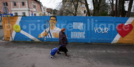 Eine Frau geht an einem Wandgemälde vorbei, das den serbischen Tennisspieler Novak Djokovic zeigt.