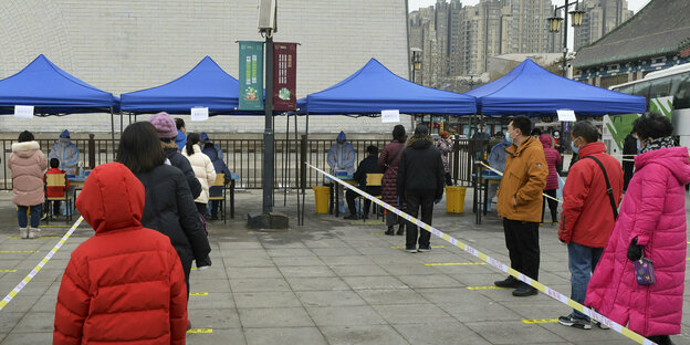Einwohner, die Gesichtsmasken tragen, um die Ausbreitung des Coronavirus einzudämmen, stellen sich zu Massentests in der nordchinesischen Stadt Tianjin auf,