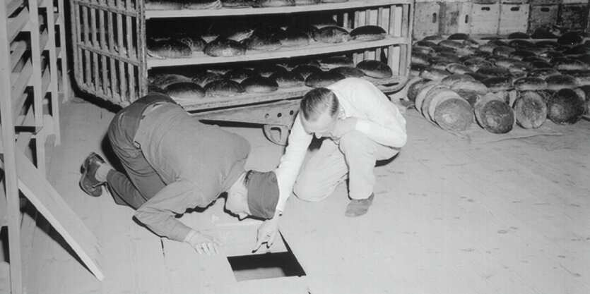 Ein US-Leutnant und ein deutscher Kriminalbeamter inspizieren die Bäckerei