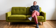 Gerhard Trabert sitzt auf einem grünen Sofa