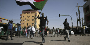 Straßenszene aus Khartum mit Menschen mit Flaggen
