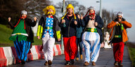 Als Figuren aus der Comicserie Asterix und Obelix verkleidete Fans gehen auf einer Straße zur Darts-WM.