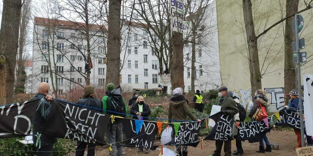 Demonstranten und Polizisten in einem - noch - mit Bäumen bestandenen Innehof in Friedrichshain, der bebaut werden soll