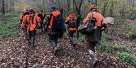 Eine Gruppe von Jägern läuft durch einen Wald