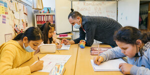 Dzoni Sichelschmidt hilft einer Viertklässlerin beim Romanes-Unterricht an der Grundschule St Pauli in Hamburg
