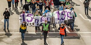 Junge Leute marschieren mit einem Transparent, welches das 1,5-Grad-Klimaschutzziel zeigt